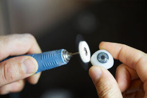 Ocularist Dwayne Collins polishing a bespoke artificial eye.
